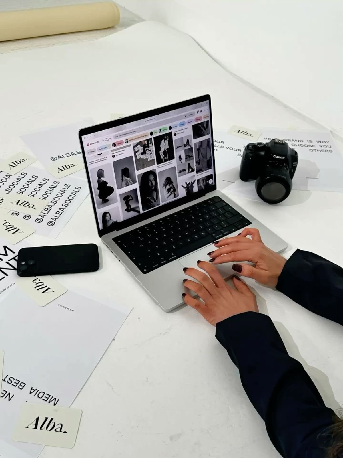 Creación de contenido con laptop, cámara y materiales de branding.